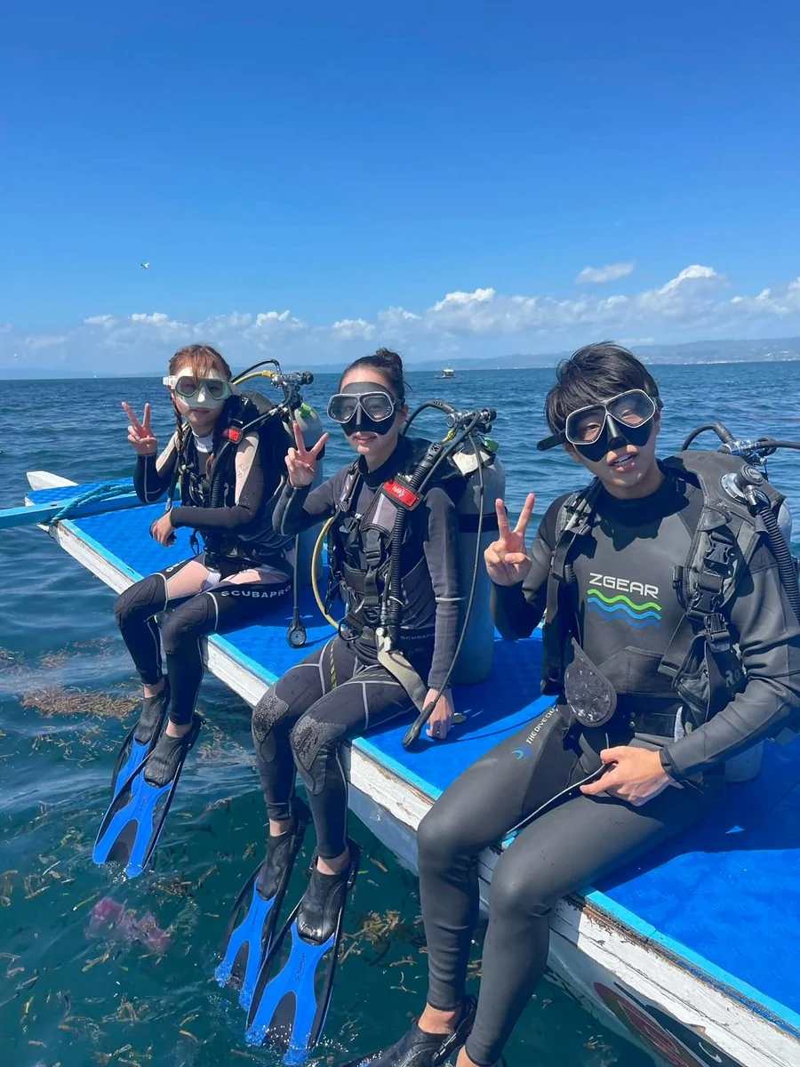 セブ島 ファンダイビング 殿様お姫様スタイル ボート上 男女ダイバーグループ ピースサイン スタッフ完全代行